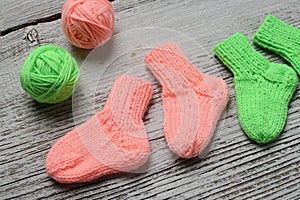 Several pairs of small woolen socks for newborn on wooden vintage table