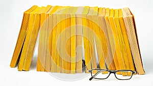 Several paperback books with a pair of glasses