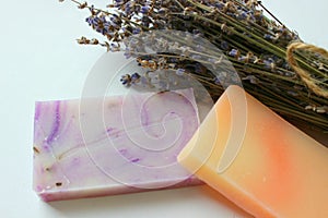 Several pieces of handmade soap and a bouquet of lavender flowers on a white background