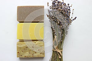 Several pieces of handmade soap and a bouquet of lavender flowers on a white background