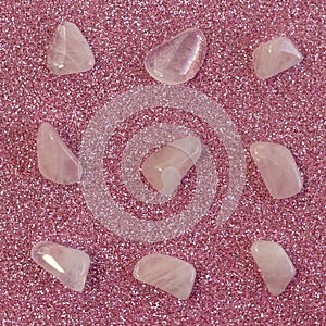 Several pieces of polished pink quartz on glitter pink background. Minimal color still life photography