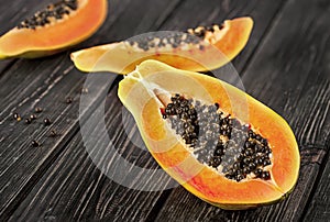 Several pieces of ripe papaya on a wooden table