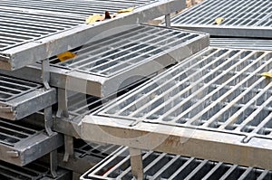 Several piling plied up sanitary drain top cover grilles grates at a construction site photo