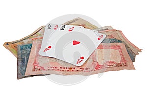 Several playing cards on a pile of cash
