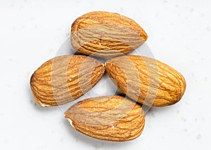Several raw almond seeds close up on gray