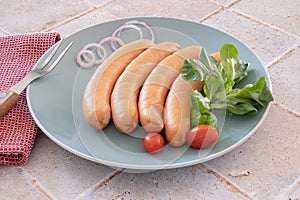 Several raw cervelas on a plate