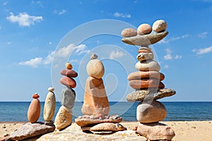 Several Rock zen pyramids of colorful pebbles on a beach on the background of the sea. Concept of balance, harmony and meditation