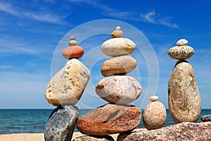 Several Rock zen pyramids of colorful pebbles on a beach on the background of the sea. Concept of balance, harmony and meditation