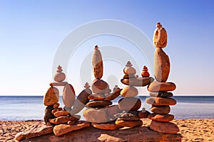 Several Rock zen pyramids of colorful pebbles standing on the beach, on the background of the sea. Concept of balance, harmony and