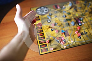 Several rolling red dice fall on a table with boardgame. Gameplay moments photo