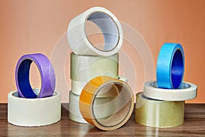 Several rolls of adhesive tape for different purposes on table.