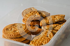 Several round coconut flavored biscuits in a transparent plastic container