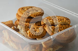 Several round coconut flavored biscuits in a transparent plastic container