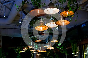 Several round loft style suspended luminaires with edison lamps shine a warm light. photo