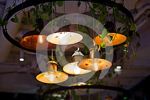 Several round pendant retro loft style lanterns with edison bulbs shine with warm light.