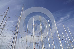 Several sail boat masts against blue sky