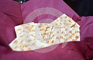 several saltine crackers in a basket lined with a dark red napkin, fresh saltines for a quick snack