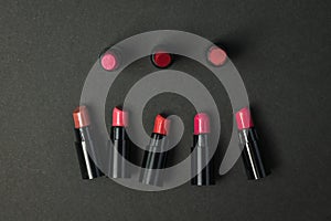 Several samples of lipstick on a black background.