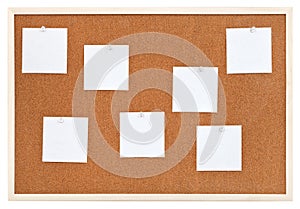 Several sheets of paper on bulletin cork board