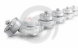 Several silver deluxe cosmetic jar on white