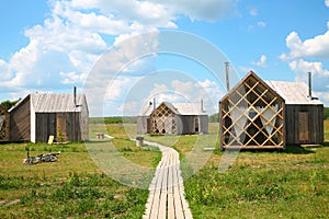 Several small guest wooden houses on meadow in photo