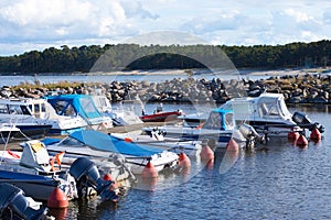 Several small motor boats moored in the small harbor on the Baltic sea