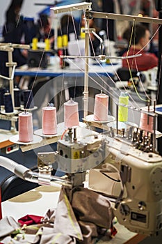 Several spools of cotton thread up at sewing machine, clothing manufacturing, industrial concept