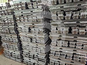 Several stacks of aluminum bars arranged, in a warehouse
