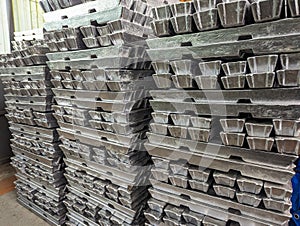 Several stacks of aluminum bars arranged, in a warehouse