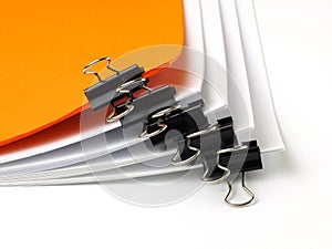 Several stacks of paper held by binder clips