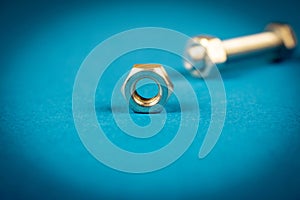 Several steel bolts and nuts on a blue background. Close-up