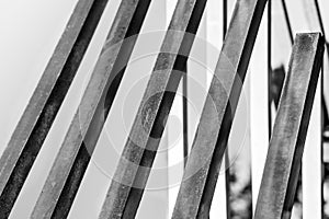 Several steel square pipes are arranged parallel to each other. Black and white photo