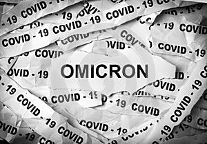 Several strips of paper printed with the words Covid-19 and Omicron. One of the strains of COVID-19