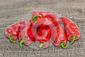 Several sweet red Kapia peppers on wooden surface