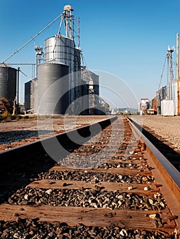 Several Tall Steel Grain Silos for Storing Crops and Railroad Tracks for Transport