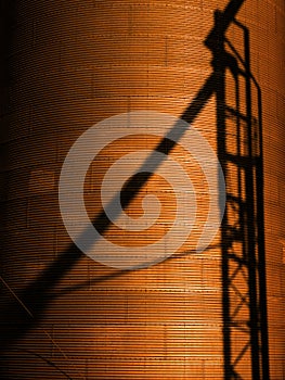 Several Tall Steel Grain Silos for Storing Crops with Shadow of Stairs