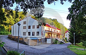 Several three-story hostels with bright walls and red roofs and in a green forest