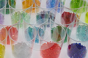 several transparent colored plastic resin granulates in test glasses photo