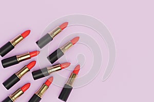 several tubes of red lipstick on a pink pastel background. copy paste, copy space. 3D render