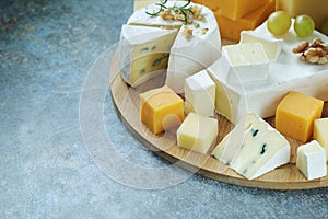 Several types of cheese served with honey and grapes