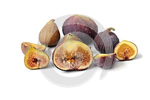 Several varieties of common fig fruits cut open showing the flesh on white background.