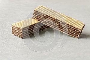 Several wafers with chocolate on a light background. Selective focus