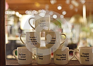 Several White Cups stacked on top that read follow your dreams, live, love, laugh and do what you love