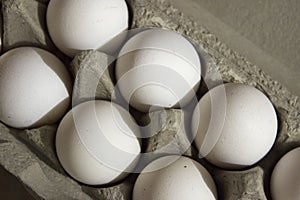 Several white eggs in an egg carton