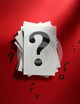 Paper notes with question marks on red background, flat lay. Space for text