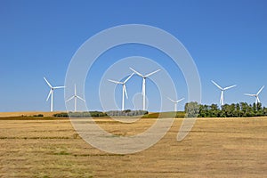 Several wind tower turbine electricity generators on a farm. Renewable energy source on a farm field