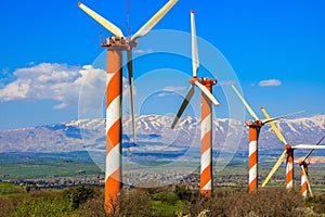 Several windmills and snow-covered Hermon