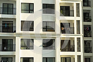 Several windows in a row on facade of urban apartment building front view in Hanoi, Vietnam