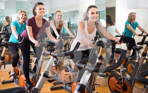 Several women of different age training on exercise bikes