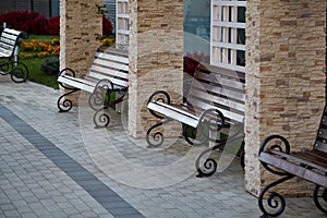 Several wooden openwork benches stand near the building